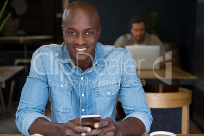 Happy man using digital tablet in coffee house