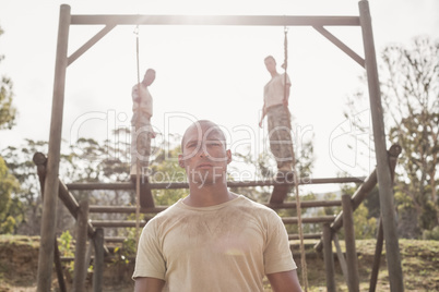 Military soldiers climbing rope during obstacle course training