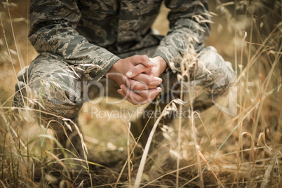 Military soldier crouching in grass