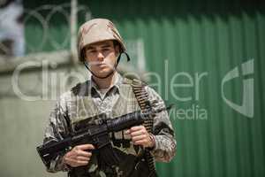 Portrait of military soldier standing with a rile