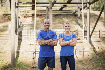 Portrait of fit man and woman standing with arms crossed