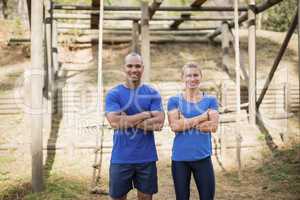 Portrait of fit man and woman standing with arms crossed