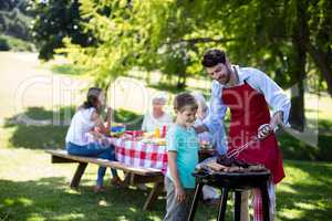 Father and son barbequing in the park