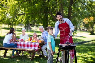 Father and son barbequing in the park during day