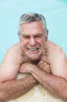 Portrait of happy senior man swimming in pool