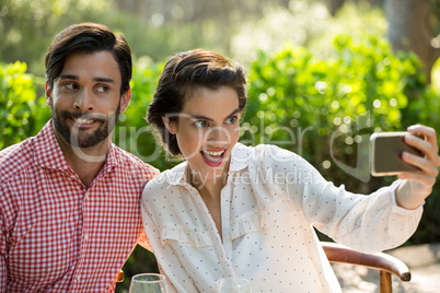 Playful couple taking slefie through smart phone