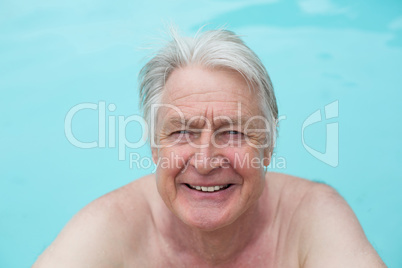 Happy senior man swimming in pool