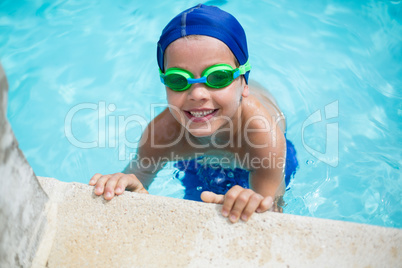 Little boy leaning at poolside