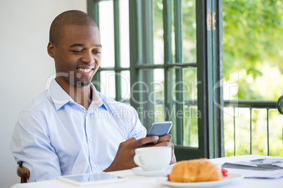 Businessman holding mobile phone in restaurant