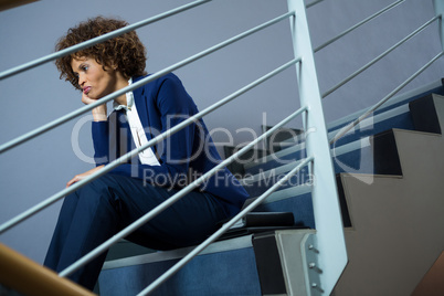 Worried businesswoman sitting on steps