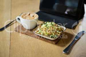 Coffee and food on wooden table in cafeteria
