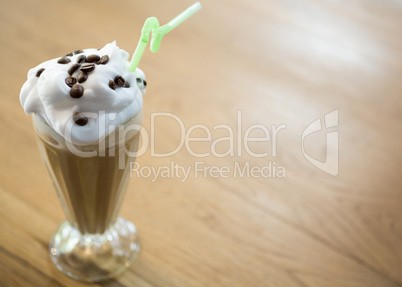 Glass of chocolate milkshake with cream in cafe