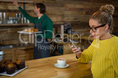 Woman using mobile phone in at coffee shop