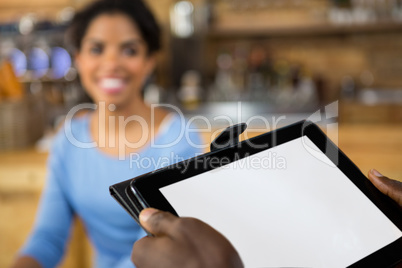 Cropped image of barista hands holding digital tablet