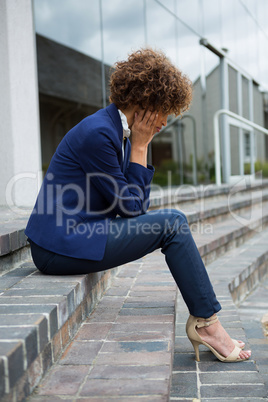 Depressed businesswoman sitting in the premises
