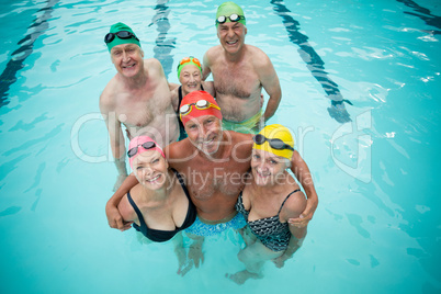Portrait of senior swimmers standing in swimming pool
