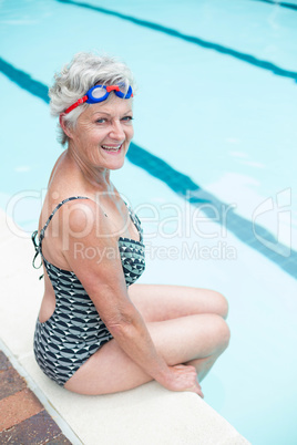 Portrait of senior woman sitting on poolside