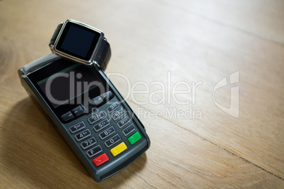 Smart watch and credit card reader on table in coffee shop