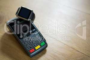 Smart watch and credit card reader on table in coffee shop