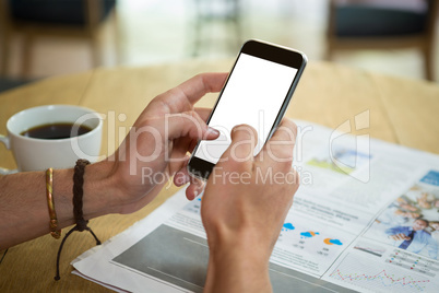 Man using mobile phone at table in coffee shop Man using mobile phone at table in coffee shop