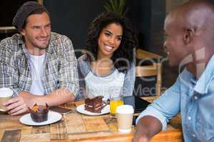 Multi ethnic friends talking at table in coffee shop
