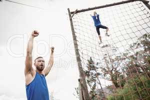 Woman climbing a net during obstacle course