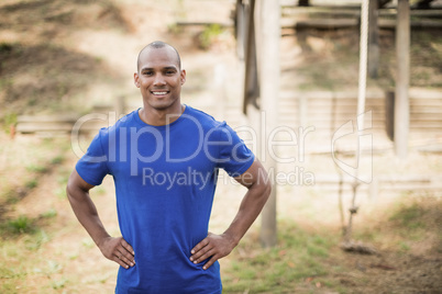 Portrait of fit man standing with hands on hip during obstacle course