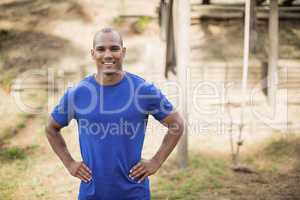 Portrait of fit man standing with hands on hip during obstacle course