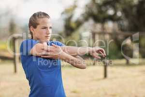 Fit woman performing stretching exercising during obstacle course