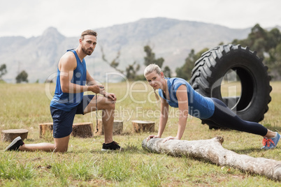 Fit performing pushup exercise while man measuring time