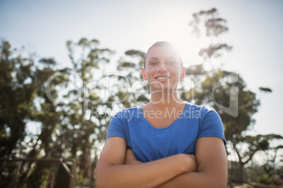 Fit woman standing with arms crossed in boot camp