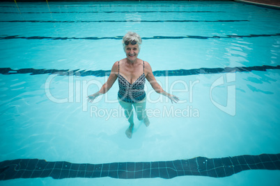 Happy senior woman swimming in pool