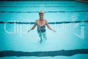 Happy senior woman swimming in pool