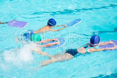 Little swimmers with kickboards swimming in pool