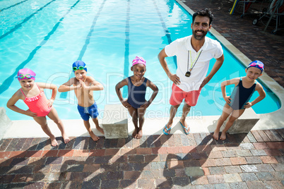Male instructor with children at poolside