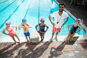 Male instructor with children at poolside