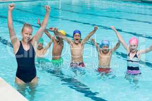 Female instructor with children enjoying in swimming pool