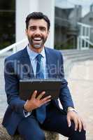 Smiling businessman using digital tablet