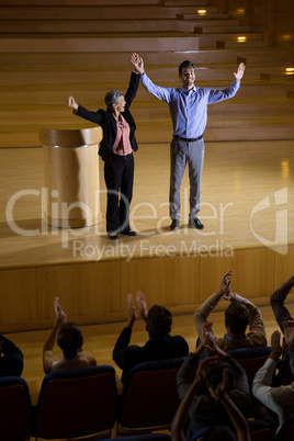 Female business executive appreciating a colleague on stage