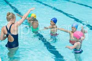 Trainer instructing students in swimming pool