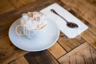 Coffee cup served on wooden table in cafeteria