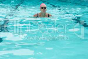 Woman wearing goggles while swimming in pool