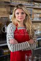 Portrait of female barista standing arms crossed in coffee shop