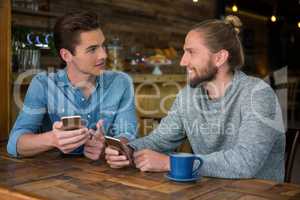 Man talking with friend at table in coffee shop