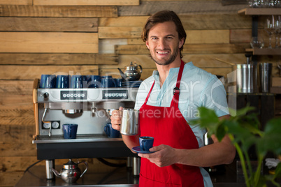 Smiling male barista making coffee in cafe