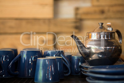 Kettle with cups and saucers on counter
