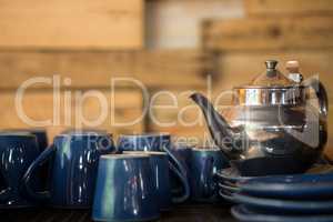 Kettle with cups and saucers on counter