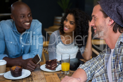 Man talking with friends at table in coffee house