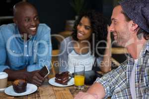 Man talking with friends at table in coffee house