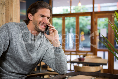 Man talking on smart phone in coffee shop